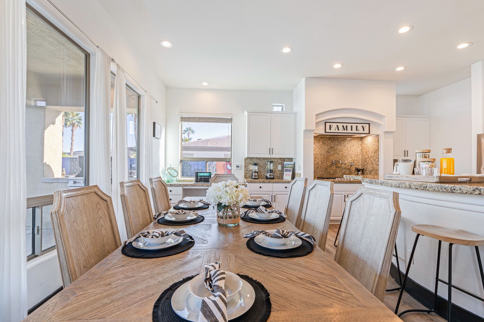 A modern kitchen with white cabinetry, a granite countertop, and a 'FAMILY' sign above the sink.