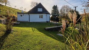 Una casa con tetto spiovente, un piccolo portico e un prato curato.