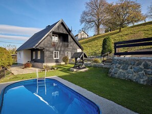 A two-story house with a swimming pool, a stone wall, and a wooden fence. - Leisure Lounge & Pool by Interhome (Kvasiny)