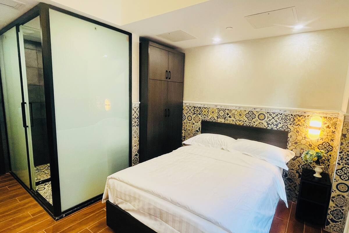 Een slaapkamer met een bed, een kledingkast en een schuifdeur van glas.