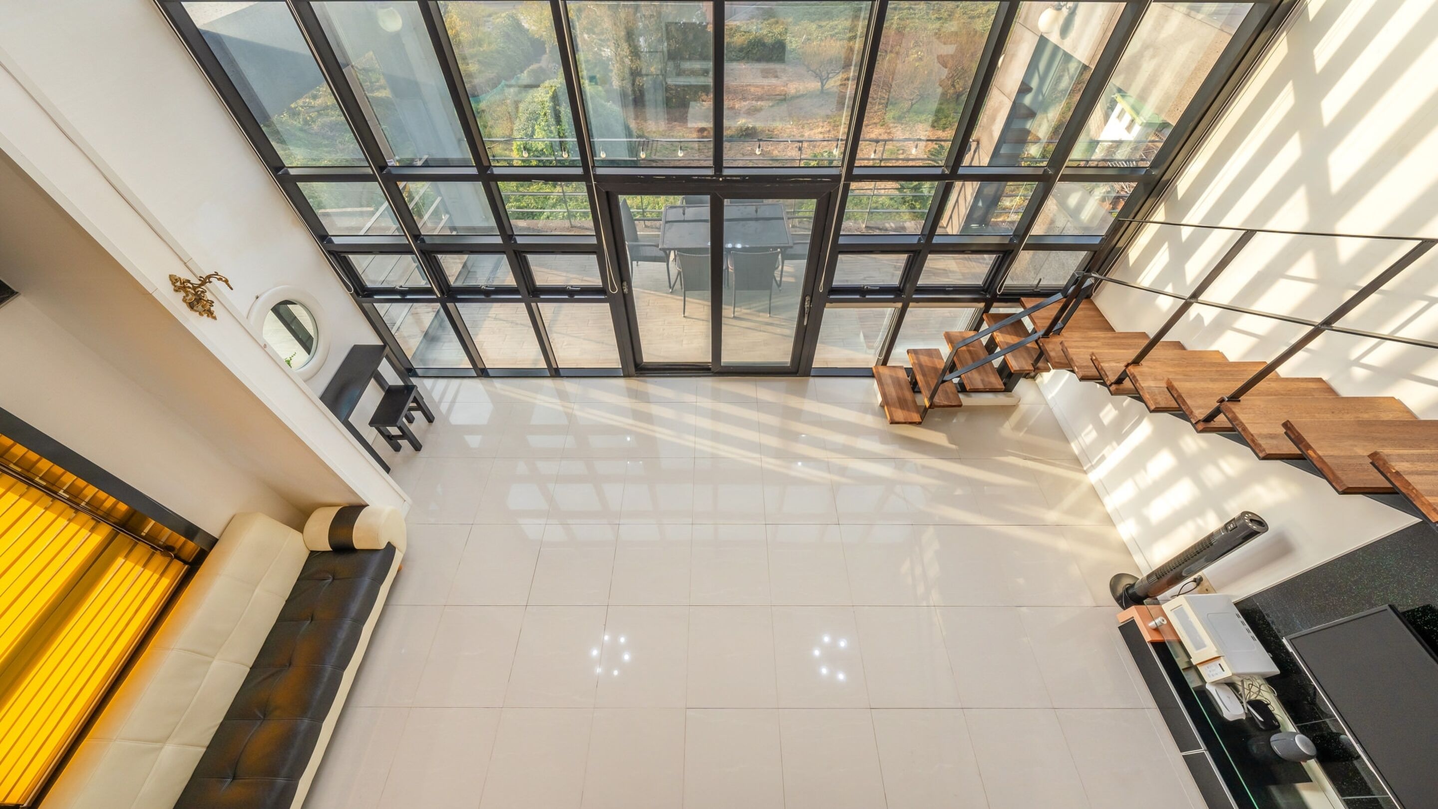 A spacious, modern interior with a large glass wall offering a view of the outdoors.