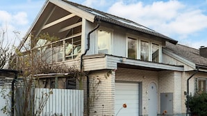 A two-story house with a balcony, a garage, and a brick facade. - 4 Star Holiday Home in Halmstad (Halmstad)