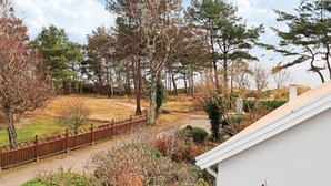 A residential area with a pathway, a fenced yard, and various trees. - 4 Star Holiday Home in Halmstad (Halmstad)