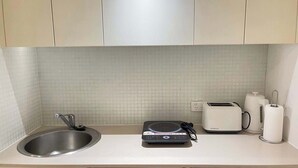 A kitchen with a sink, a toaster, a kettle, and a coffee maker on the counter. - MetaWise 2Bed Next to ICC Darling Harbour 65 (Sydney)