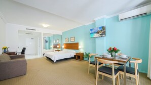 A hotel room with a bed, a desk, a dining table with chairs, and a TV on the wall. - MetaWise 2Bed Next to ICC Darling Harbour 65 (Sydney)