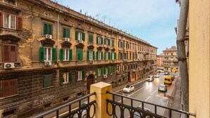 A multi-story building with green shutters, a street in front, and a bus in the distance. - Lovely apartment in Rijeka with WiFi (Rijeka)