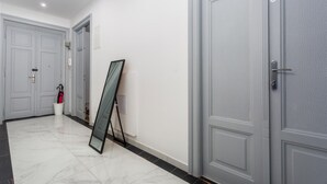 A hallway with grey doors, a glass door frame leaning against the wall, and a white bucket with a red umbrella. - Lovely apartment in Rijeka with WiFi (Rijeka)