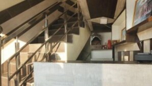 A modern interior with a staircase, a kitchen area, and a seating space. - HR Rama Palace (Haridwar)