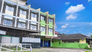A multi-story building with a green facade and a blue door. - Hotel O Ilir Timur I Near Rsud Siti Fatimah Az-Zahra Formerly Lumendiva Suite (Palembang)