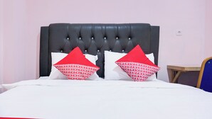 A bed with a black headboard, white bedding, and two red pillows with white text. - Hotel O Ilir Timur I Near Rsud Siti Fatimah Az-Zahra Formerly Lumendiva Suite (Palembang)