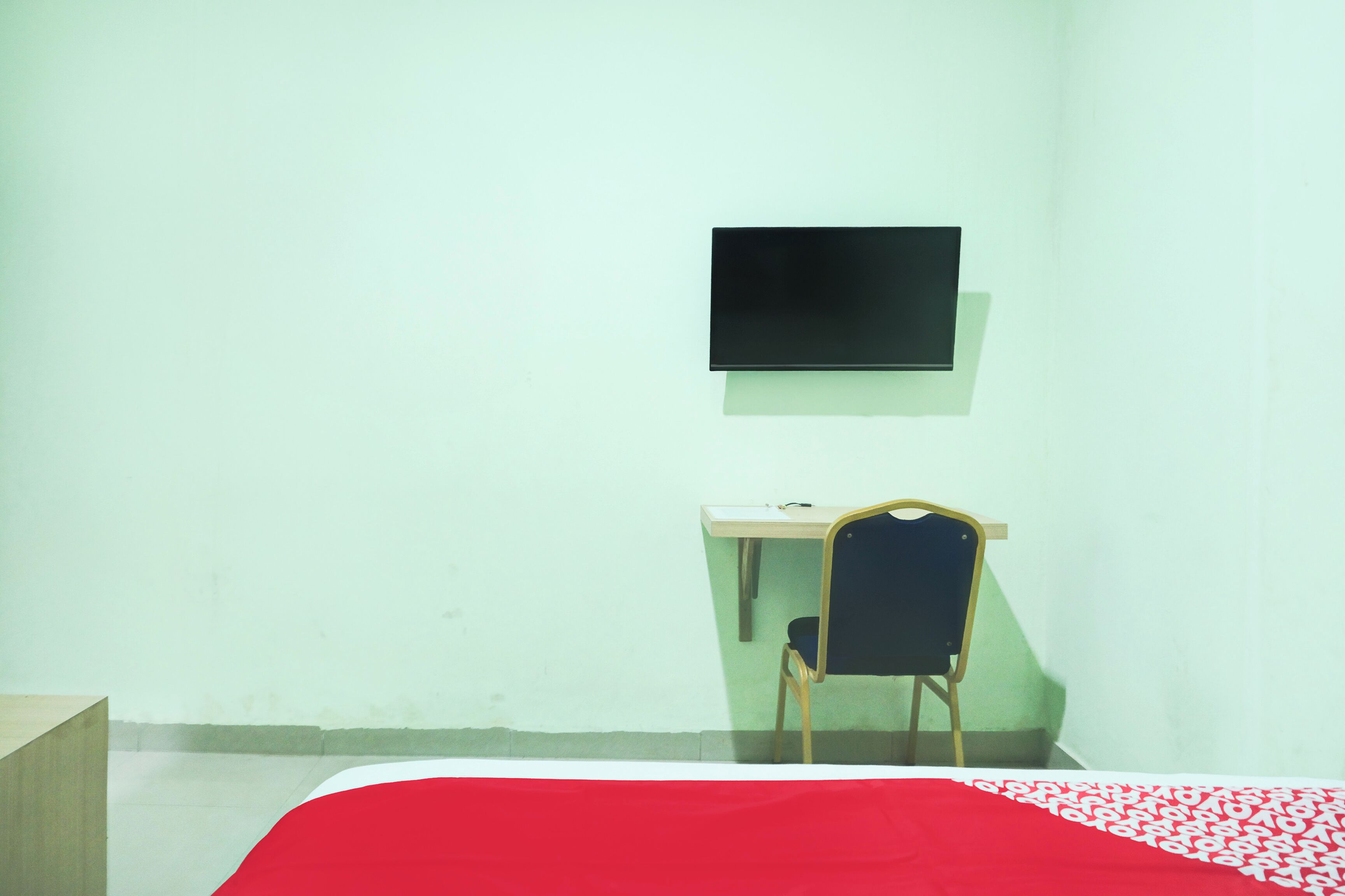 A room with a bed, a desk, and a chair.