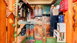 Una cocina rústica con muebles de madera, una pizarra con un mensaje y un teléfono rojo.