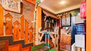 Una cocina rústica con detalles de madera, un muro de ladrillo y una escalera de madera.