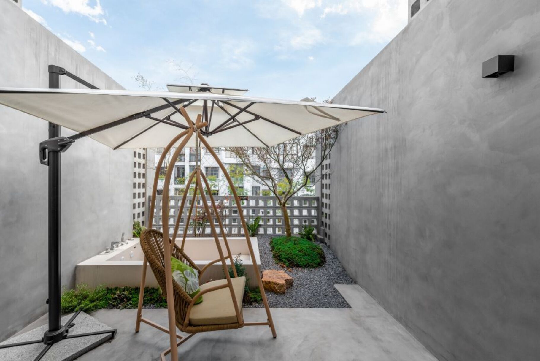 A patio area with a swing chair and a large umbrella.