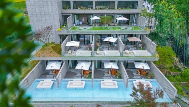 A multi-story hotel with outdoor seating areas and a swimming pool. - HUANG GUO SHU DUO BEI YUN SHE HOTEL (Anshun)