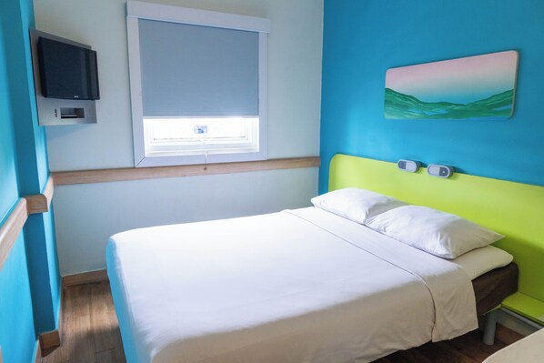 A bedroom with a bed, a television, a window, and a painting on the wall. - The Suddha Asia Afrika Bandung (Bandung)
