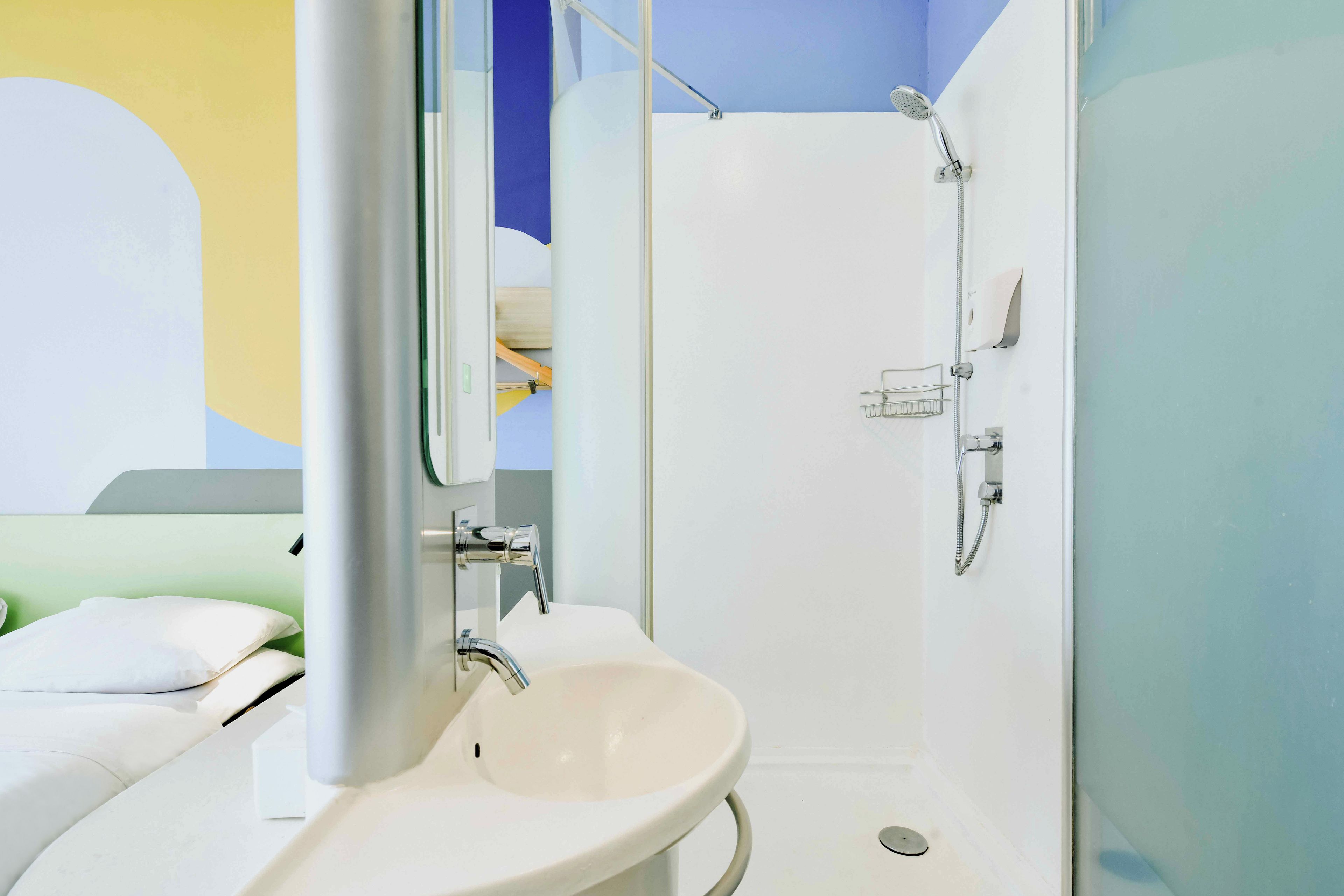 A bathroom with a white sink, a mirror, and a shower.