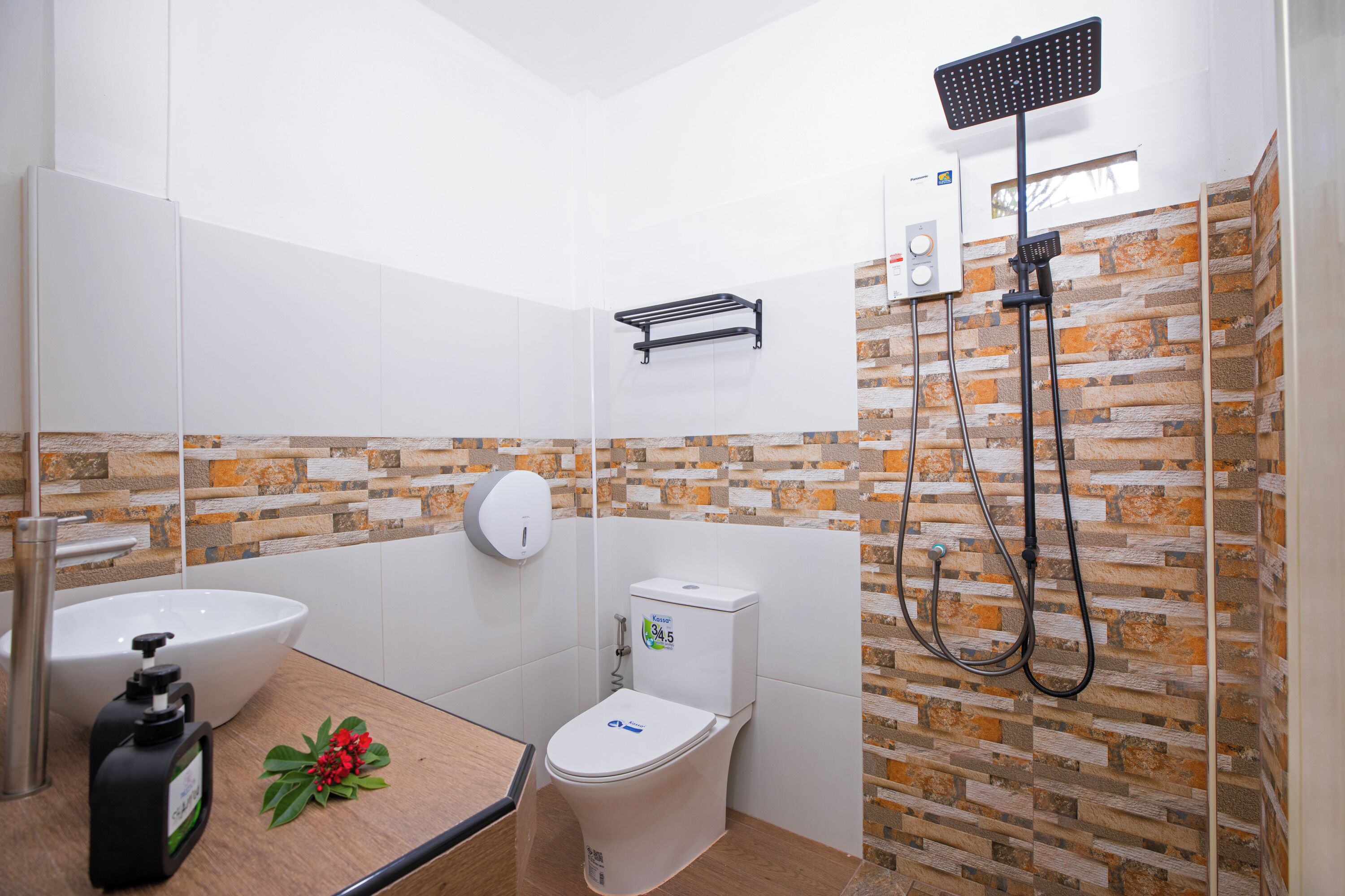 Un baño moderno con lavamanos, inodoro y ducha blancos.