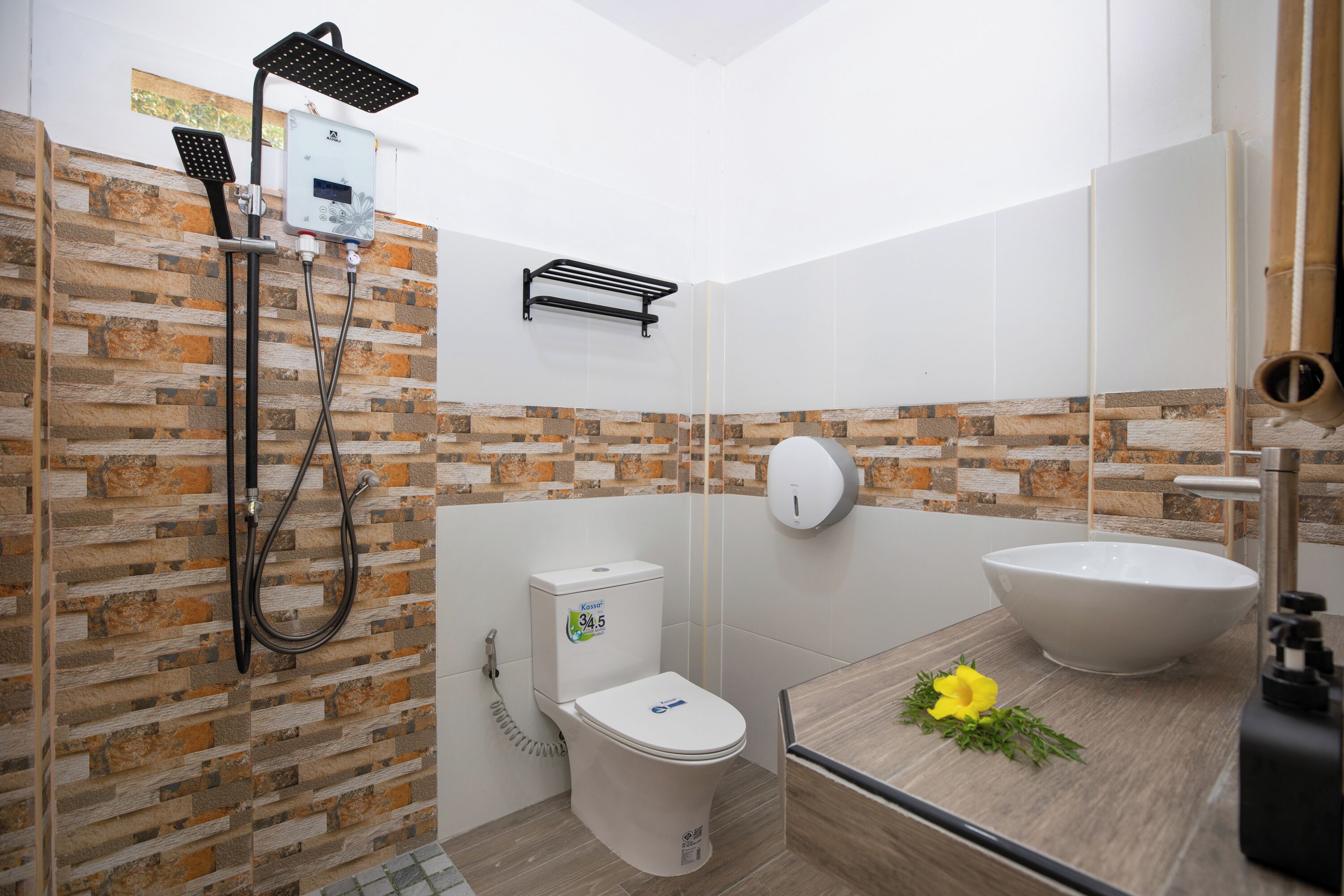 A bathroom with a toilet, a sink, a shower, and a towel rack.