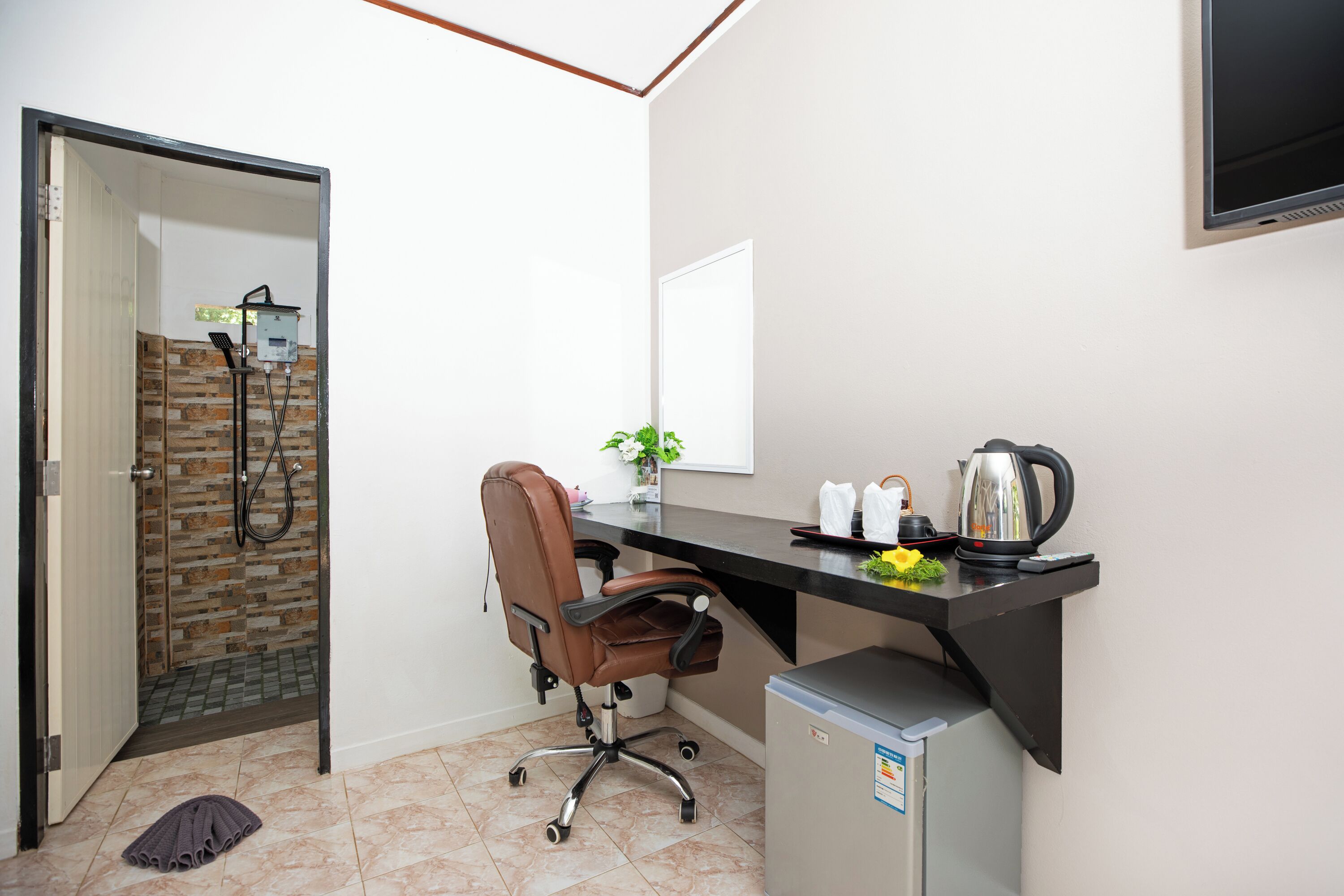 Un petit bureau comprenant un bureau, une chaise et un coin cuisine.