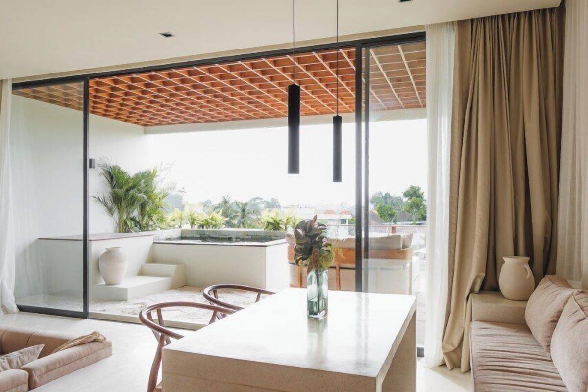 A modern living room with a central island, a sofa, and a dining area.