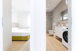 A modern bathroom with a shower, toilet, and washing machine. - Luxury Living at Horizon Retreat (Marina)