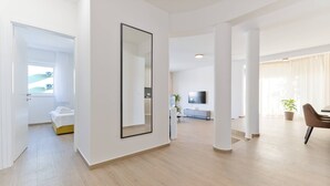 A spacious living area with a large mirror, a dining area, and a kitchen in the background. - Luxury Living at Horizon Retreat (Marina)