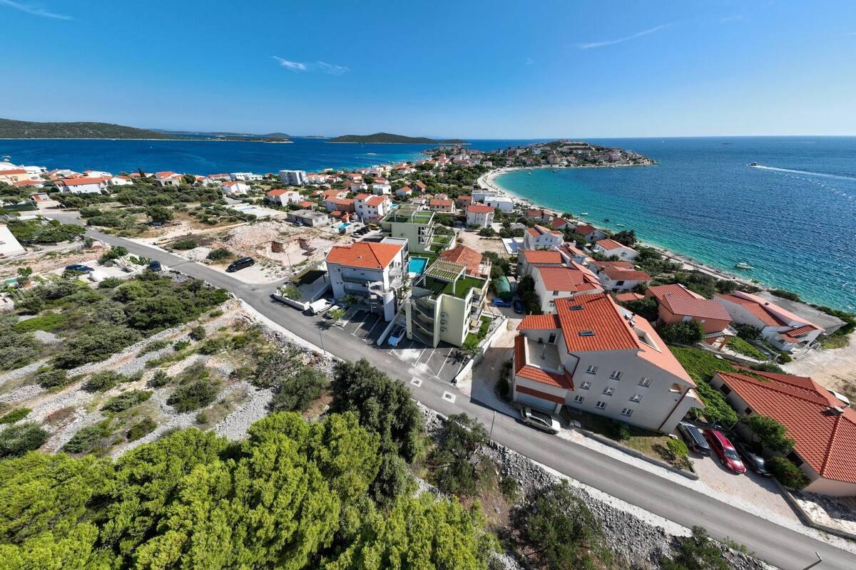 An aerial view of a coastal town with buildings, roads, and a beach.
