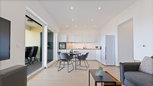 A modern apartment with a dining area, kitchen, and living space. - Luxury Living at Horizon Retreat (Marina)