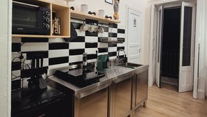 Una cocina moderna con salpicadero a cuadros blancos y negros, electrodomésticos de acero inoxidable y encimera de madera.