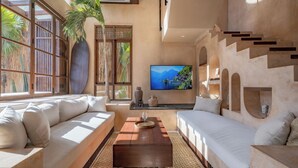 A modern living room with a sofa, a coffee table, and a TV. - Villa Alma at Bocoa Villas (Canggu)