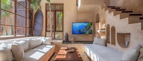 A modern living room with a sofa, a coffee table, and a TV.