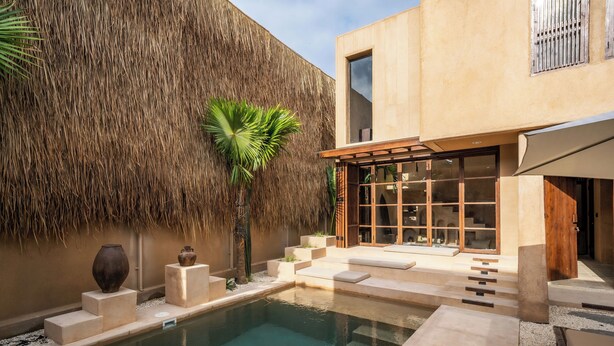 A modern pool area with a thatched wall, a glass-enclosed patio, and a minimalist design. - Villa Alma at Bocoa Villas (Canggu)