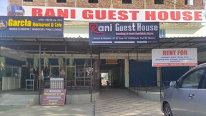 A building with multiple signs advertising a guest house, a restaurant, and a rental service. - Rani Guest House (Guwahati)