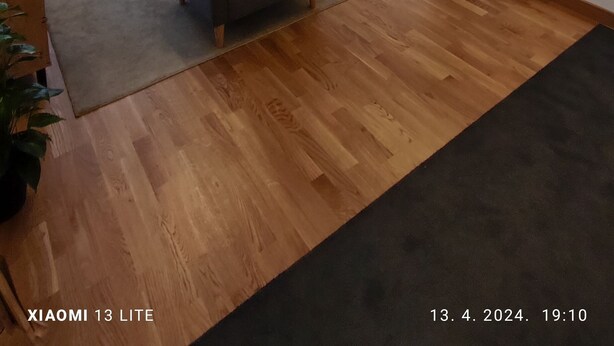 A modern living room with a sofa, a coffee table, a lamp, and a bookshelf. There is a window with a view of the outdoors. - Cozy apartment in tranquil Podgorica with WiFi, AC (Podgorica)