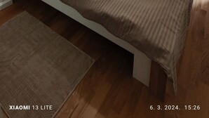 A bedroom with a bed, bedside tables, a nightstand, a lamp, a window with blinds, and a hanging light fixture. - Cozy apartment in tranquil Podgorica with WiFi, AC (Podgorica)