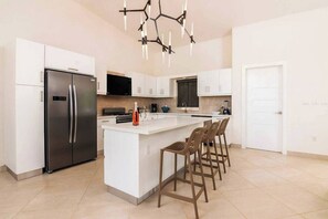 Fridge, stovetop, cookware/dishes/utensils, dining tables