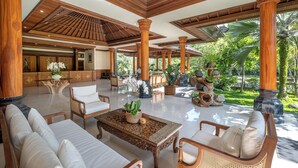 A spacious lobby with wooden columns, comfortable seating, and a view of the garden. - Samujha Ubud Resort (Ubud)
