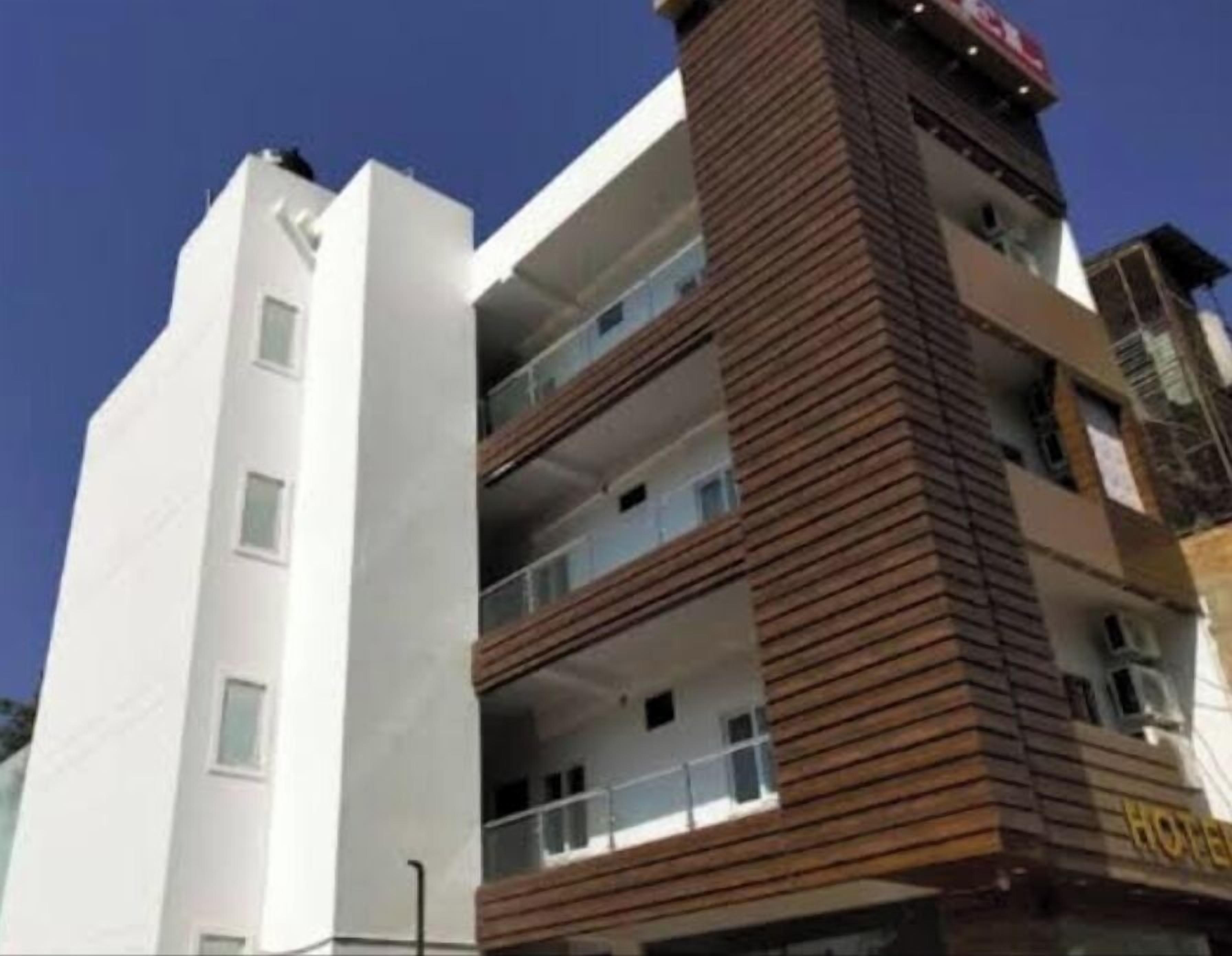 Een hotel met meerdere verdiepingen, een witte gevel en een bruine accentmuur.