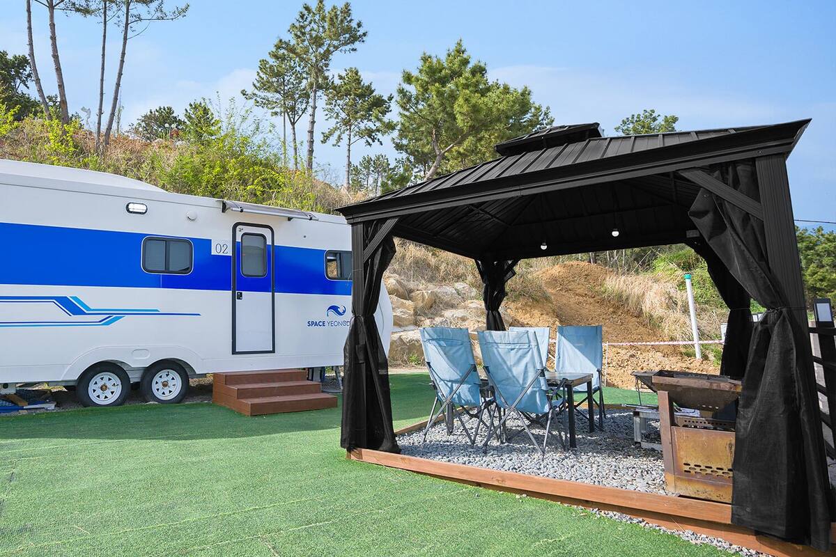 Un camping-car Forest Caravan doté d’un espace salon extérieur abrité.