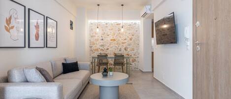 A modern living room with a sofa, a round coffee table, and a stone wall.