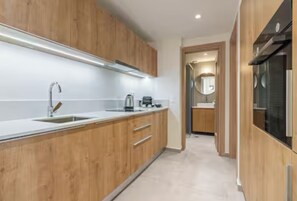 A modern kitchen with wooden cabinets, a stainless steel sink, and a built-in oven.