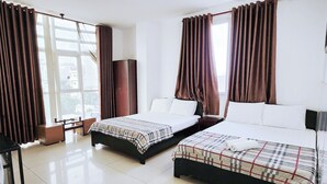 A hotel room with two beds, a wardrobe, a table, and a chair. - Kinh Bac Hotel (Ho Chi Minh City)