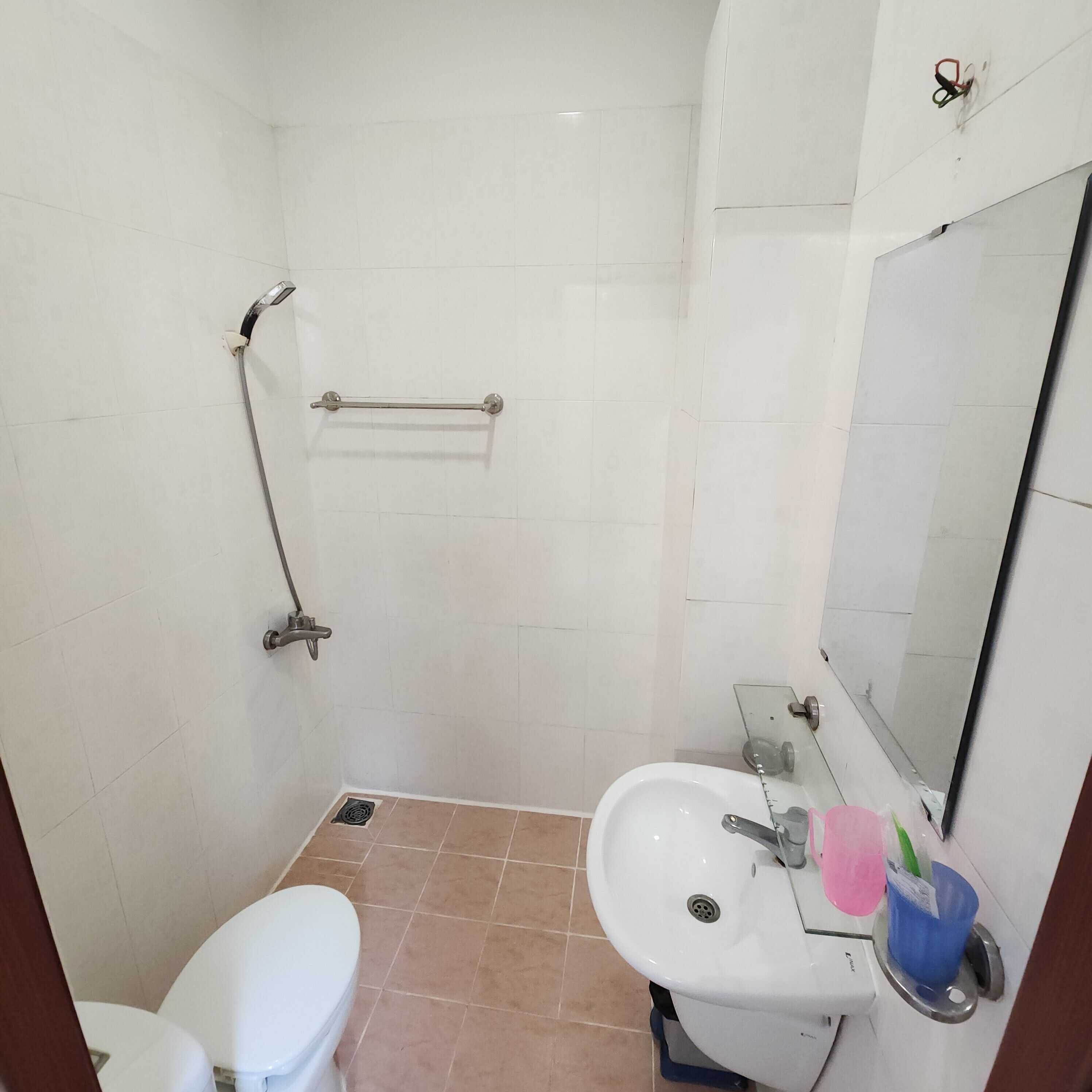 A bathroom with a toilet, sink, and shower.