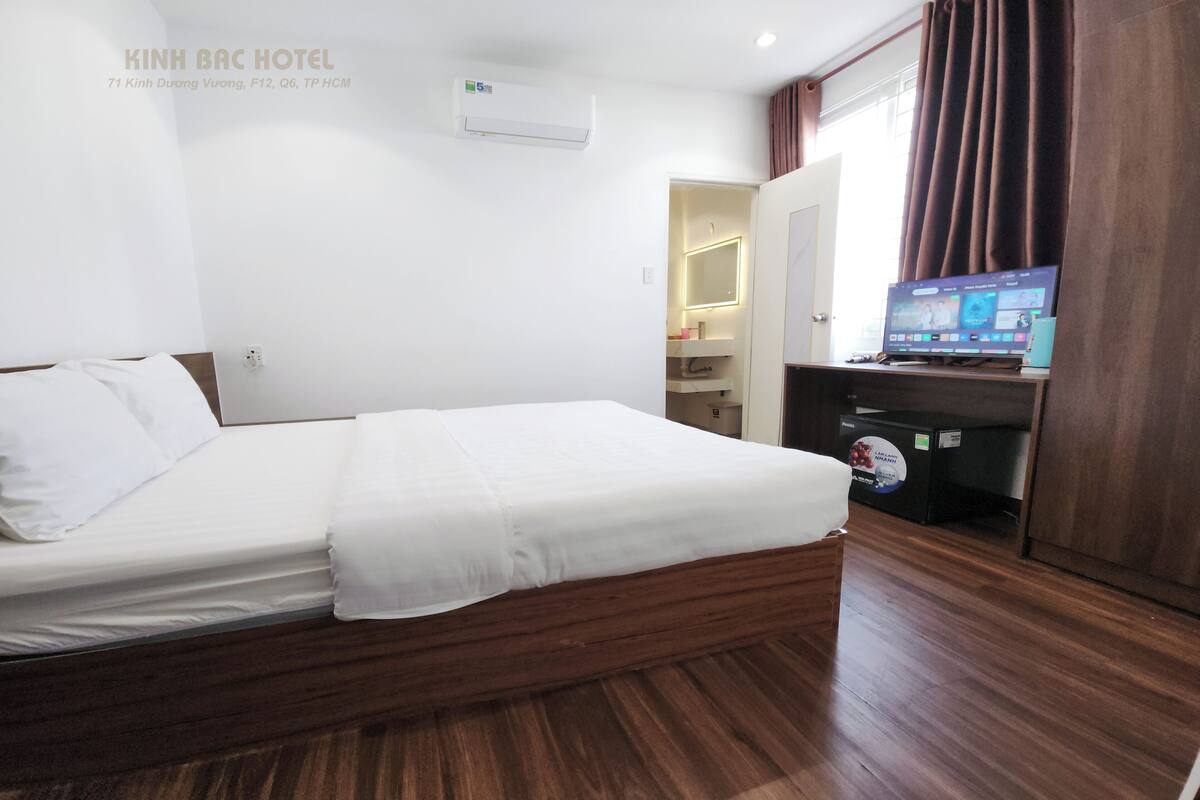 A hotel room with a bed, a television, and a desk with a computer.