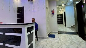 Zona de recepción de hotel con diseño moderno, suelo de mármol y mostrador.
