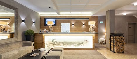 A reception area with a wooden counter, seating, and a large mirror.