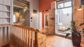 A spacious room with a wooden staircase, a large window with a view, and a potted plant. - It's ideal for families
or groups of up to seven people. (Chania)