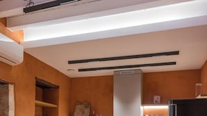 A modern kitchen with a wooden dining table, a black refrigerator, and a built-in oven. - It's ideal for families
or groups of up to seven people. (Chania)