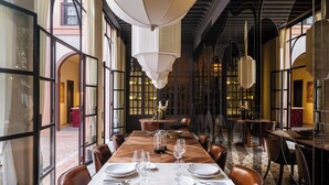 A dining area with a long wooden table set for six, surrounded by leather chairs. - This Time Tomorrow in Marrakech (Marrakech)